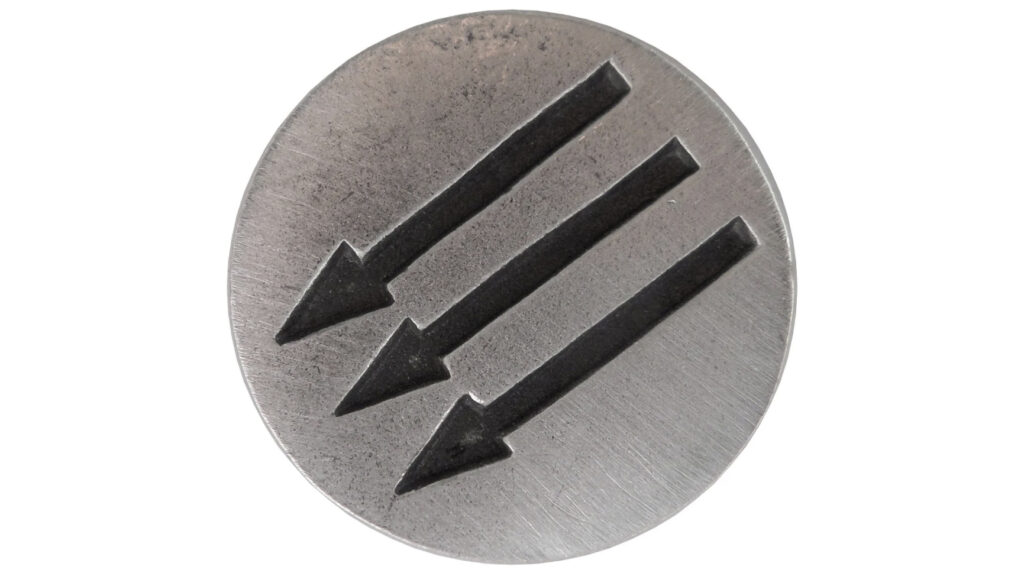Photo of round pewter pin silhouetted against a white background. Pin is medium silver gray, slightly weathered, and has three parallel black arrows debossed across it. Arrows are pointing down and to the left at a 45-degree angle.