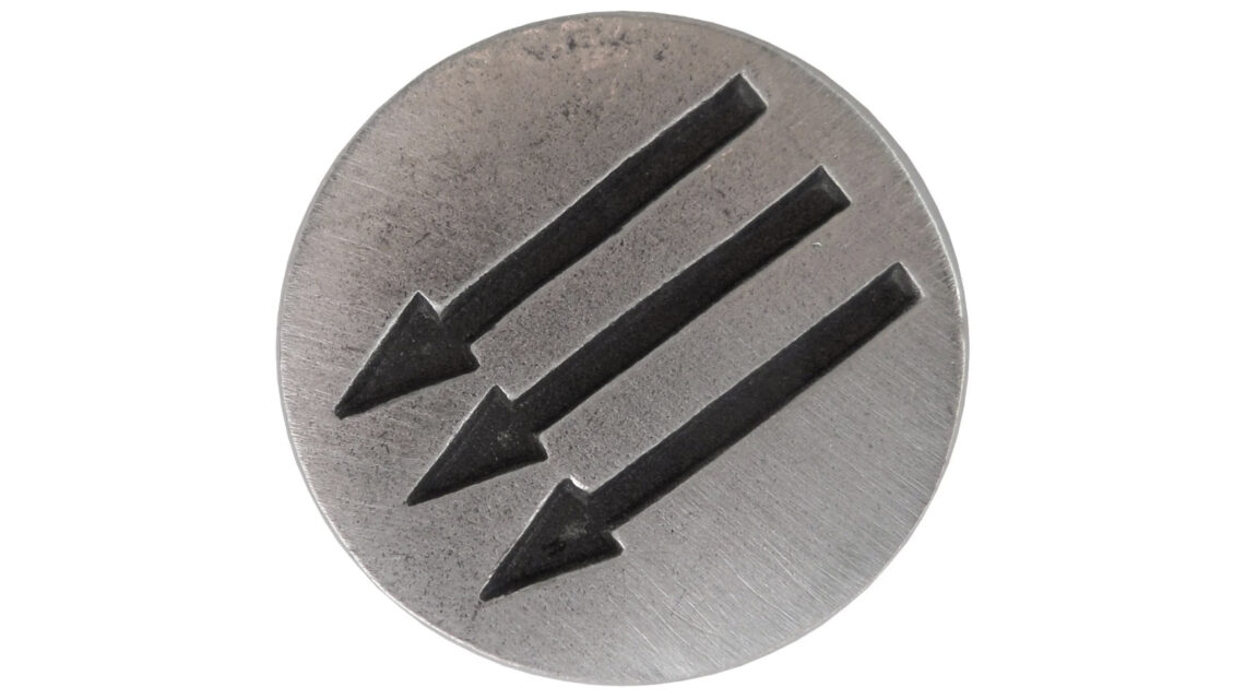 Photo of round pewter pin silhouetted against a white background. Pin is medium silver gray, slightly weathered, and has three parallel black arrows debossed across it. Arrows are pointing down and to the left at a 45-degree angle.